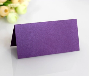 Close-up of a purple pearlescent place card with elegant dried flowers for weddings