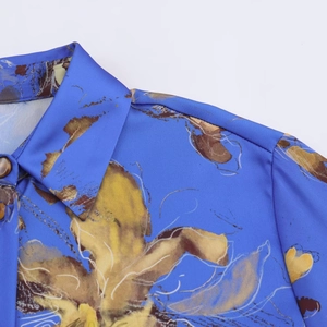 Dettaglio ravvicinato della camicia in raso a fiori con trama del tessuto e colletto