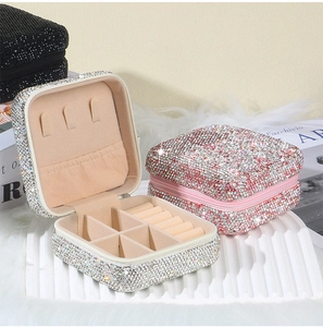 Detail of square jewelry box with rhinestone finish, zipper closure and velvet interior