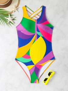 Detailed flat lay of a colorful patchwork swimsuit with cross back and tropical prints