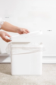 Detail showing the removable top lid for easy trash bag installation on a white bin