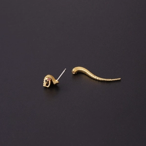 Creative gold snake screw cartilage stud earring with red gemstone eyes on black background