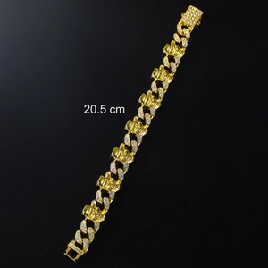 Macro detail of gold Cuban link bracelet with skull embossing and pavé rhinestones