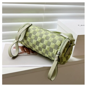 Detail of green checkerboard cylinder bag with 3D bubble texture and long zipper pull