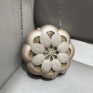 Detail of flower-shaped champagne evening bag with silver crystals and metal chain strap