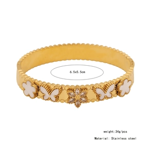 Detail showing golden stainless steel bangle with shell butterflies and clover patterns