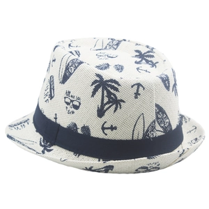 Detail of nautical print straw fedora hat featuring blue palm trees and surf patterns