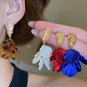 Close-up of vintage acrylic petal tassel earrings in amber, white, red, and blue colors