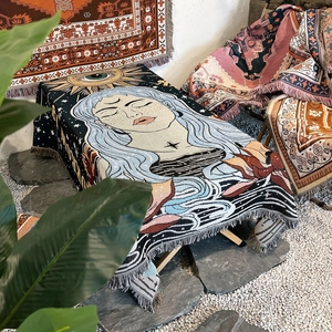 Close-up of bohemian woven blanket featuring fringe edges and mystical sun moon patterns