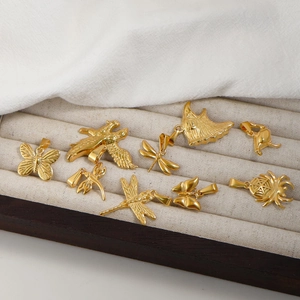 Detailed view of 24K gold plated animal charms including dragonfly and butterfly on velvet