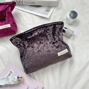 Detail of plush velvet makeup bags in purple and magenta with embossed texture