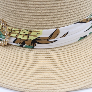 Détail d'un chapeau en paille avec ruban floral et boucle ornée de strass brillants