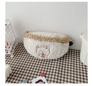 Close-up of white plush crossbody bag with cute brown bear embroidery and fleece texture