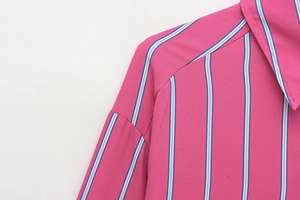 Detail of lapel and shoulder seam on fuchsia striped loose long sleeve shirt