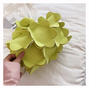 Detailed view of the 3D flower petal pattern on this light green faux leather handbag