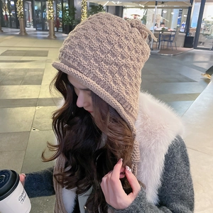 Close-up of a coffee brown knit beanie with textured diamond pattern and ear flaps