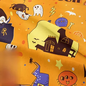 Close-up of Halloween tapestry fabric showing soft orange knit texture and cartoon prints