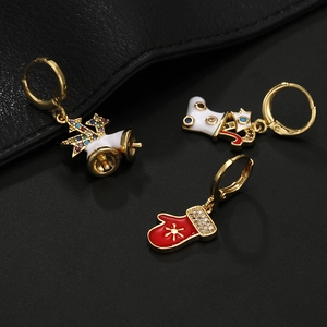 Macro view of Christmas enamel hoop earrings with rhinestone bells, socks and gloves