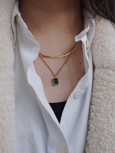 Close-up of double-layered gold snake chain featuring a rectangular emerald zircon pendant