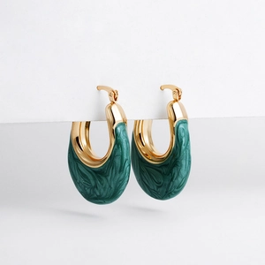 Macro detail of gold-plated U-shaped hoop earrings with green marbled enamel inlay