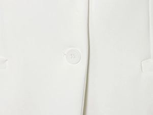Vue macro du tissu tissé blanc avec bouton assorti et détails de couture précis