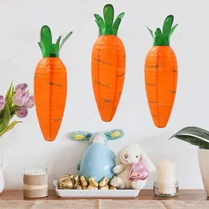 Three carrot-shaped paper lanterns hanging as decorative Easter party ornaments