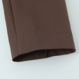 Detailed close-up of brown blazer cuff fabric showing premium stitching and weave texture