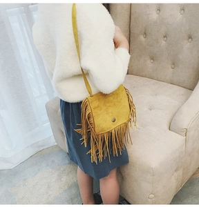 Kids leopard suede crossbody bag with tassels shown on a girl model in a cozy interior