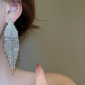 Gros plan sur des boucles d'oreilles trapèze géométriques avec strass brillants