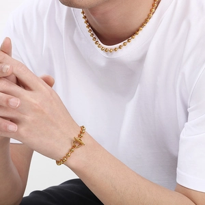 Ensemble collier et bracelet à billes dorées avec fermoir à bascule sur mannequin