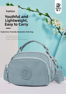 Detail of Morandi blue crossbody bag showing its nylon texture and front zip pocket