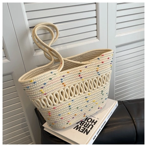 Close-up of cream woven tote bag with colorful specks and hollow wave pattern