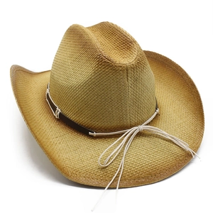 Detail of woven straw cowboy hat featuring gradient brim and vintage leather strap band