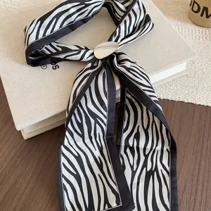 Zebra print silk scarf necklace with silver oval buckle on vintage wooden background