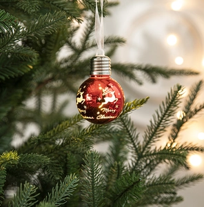 Detailed view of a red light bulb ornament with gold reindeer and Merry Christmas print