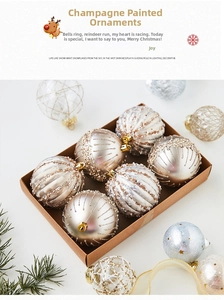 Detailed view of champagne gold and white painted Christmas ornaments in a gift box