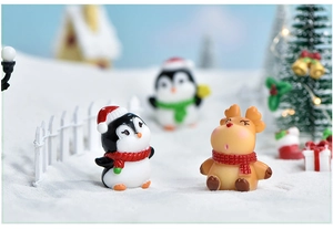Macro detail of miniature Christmas penguin and reindeer resin figures for DIY decor