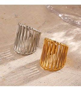 Macro shot of 18K gold and silver chunky hollow lined rings on stone texture background