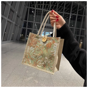 Linen tote bag detail with woven floral pattern, cotton rope handle and wooden button
