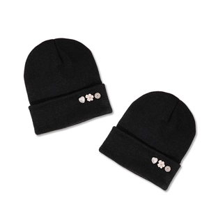 Two-pack black knit beanies featuring decorative heart and flower button accents