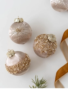 Close-up of champagne gold Christmas balls with sequin embroidery and pearl beads