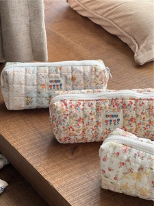 Detail of floral quilted cotton pencil cases with zippers and vintage style fabric labels