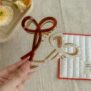 French hollow bow hair claws in amber tortoise and marble white acetate finish