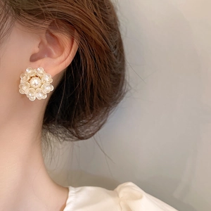 Floral pearl cluster earrings worn by a model in a minimalist French aesthetic style