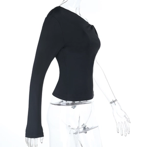 Detail of the slim fit off-shoulder knot design and sleek knit fabric on the black top