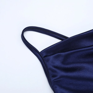 Gros plan détaillé des bretelles de la robe en satin bleu foncé et des coutures fines