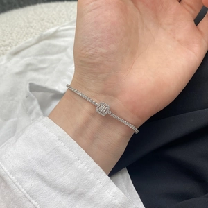 Close-up of S925 silver tennis bracelet with square geometric pendant on a female wrist
