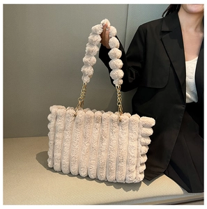 Detail of beige plush tote bag featuring vertical stripe texture and soft bubble handle