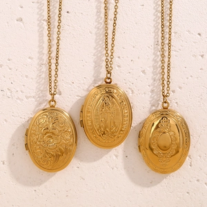 Detailed view of 18K gold-plated oval locket pendants with vintage floral engravings