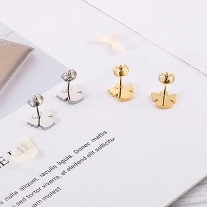Detailed view of gold and silver angel wing stud earrings in a minimalist style